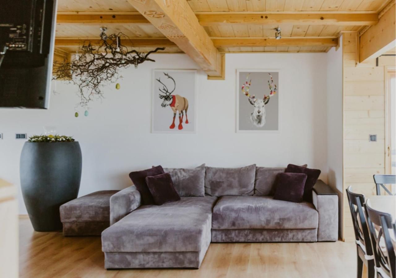 Jasny salon z drewnianym stropem i narożną sofą